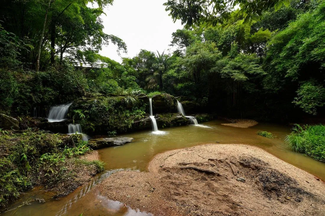 Vista ampla da cachoeira e do leito do rio