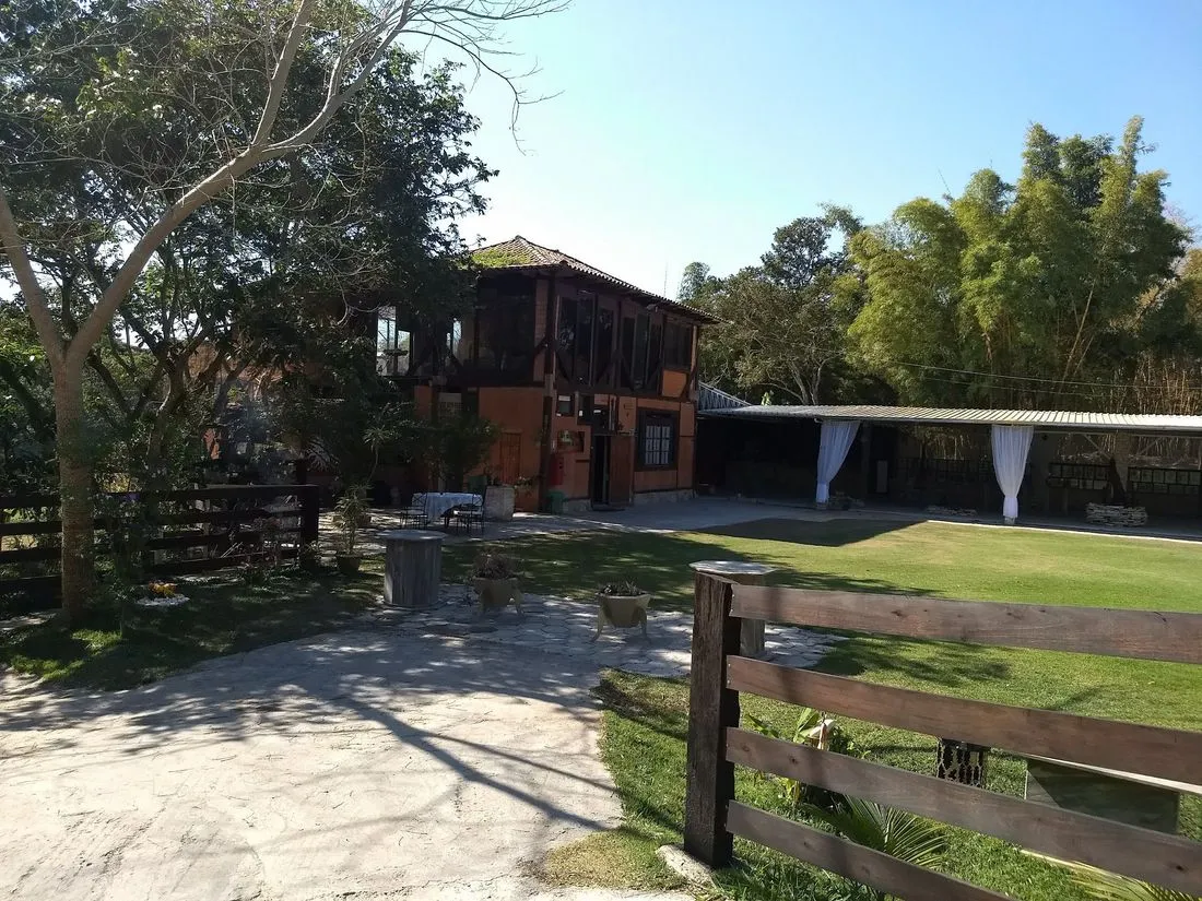 Construção em madeira da Reserva, com o gramado e a área coberta de eventos