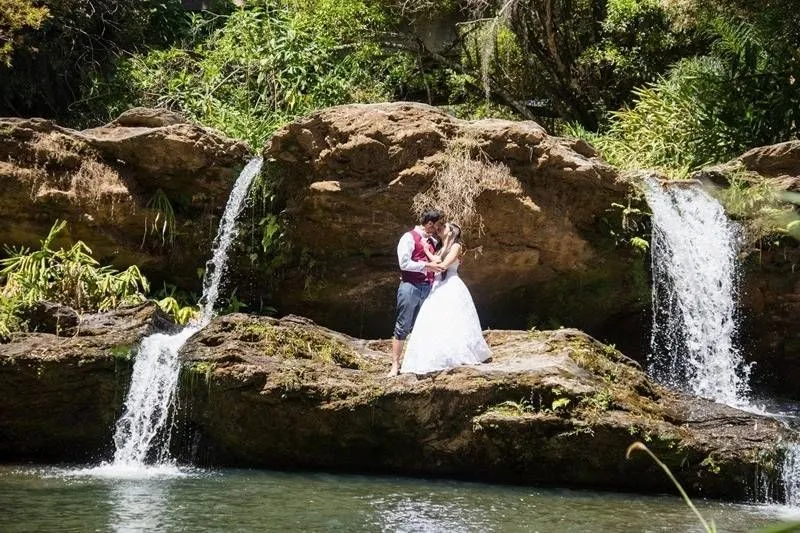 Casal de noivos sobre a pedra, entre duas quedas d'água da Reserva